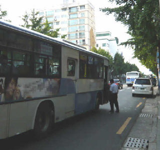 위험하게 차도까지 나와서 버스에 탑승하고 있는 시민 